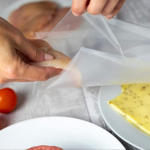 Utilizzo pratico sacchetti sottovuoto Reber, mani che sigillano alimenti per conservazione ottimale, facile da usare