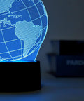 Dettaglio lampada globo 3D con illuminazione LED blu che mostra America del Sud e continenti, effetto tridimensionale realistico